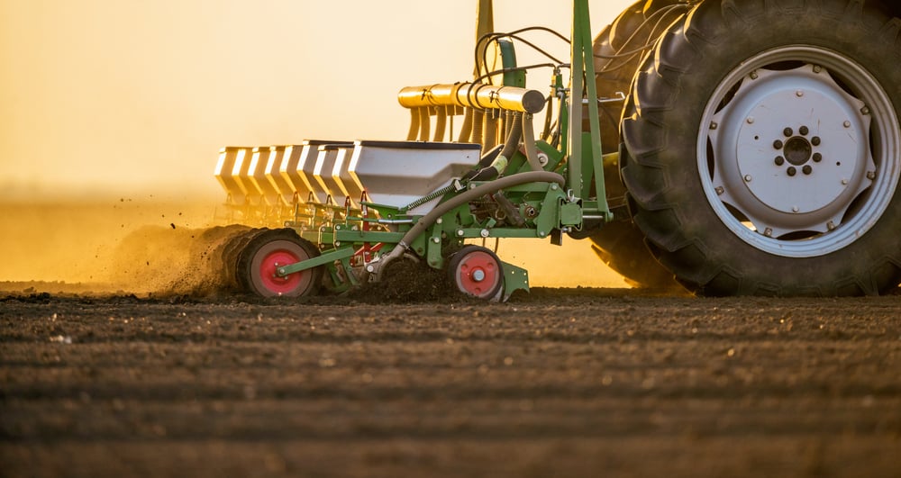 tractor Sowing crops in field. shutterstock_1909079617